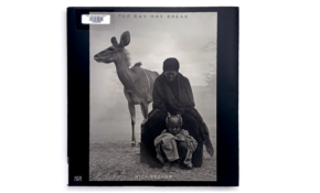 Book cover featuring sepia photograph of a parent, child, and pack animal, with hazy background.