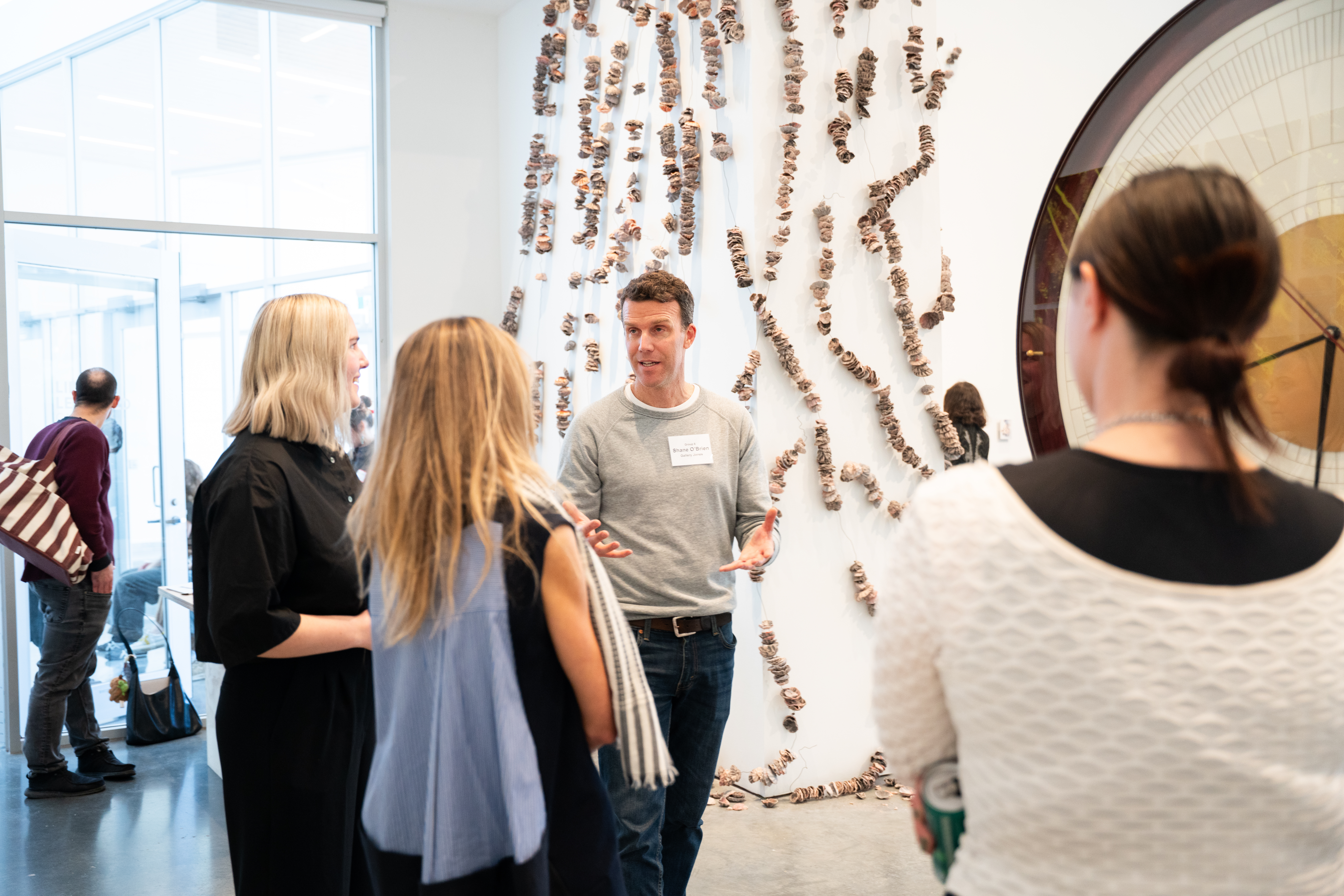 A group of four people discuss an artwork