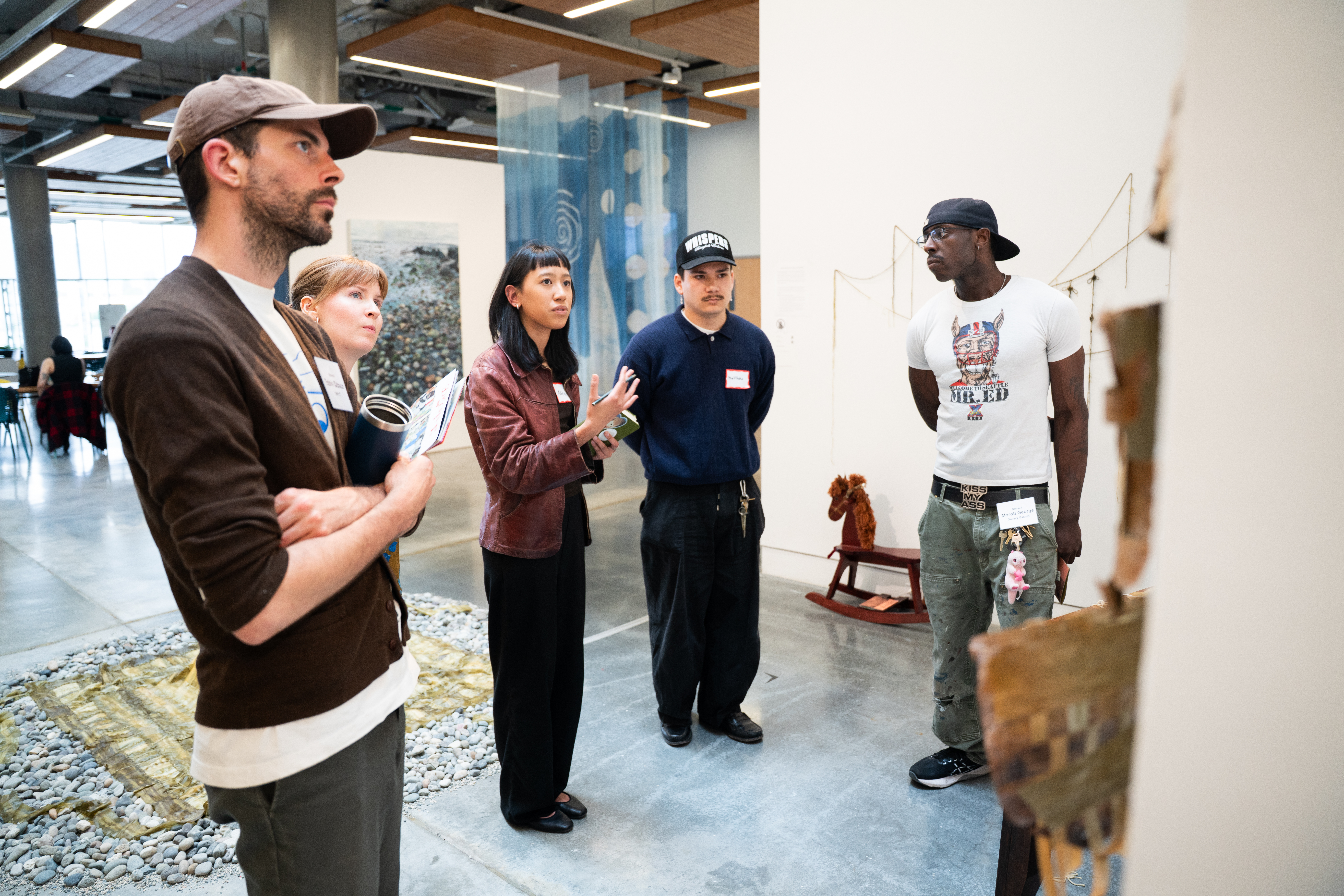 A group of five people look at an artwork