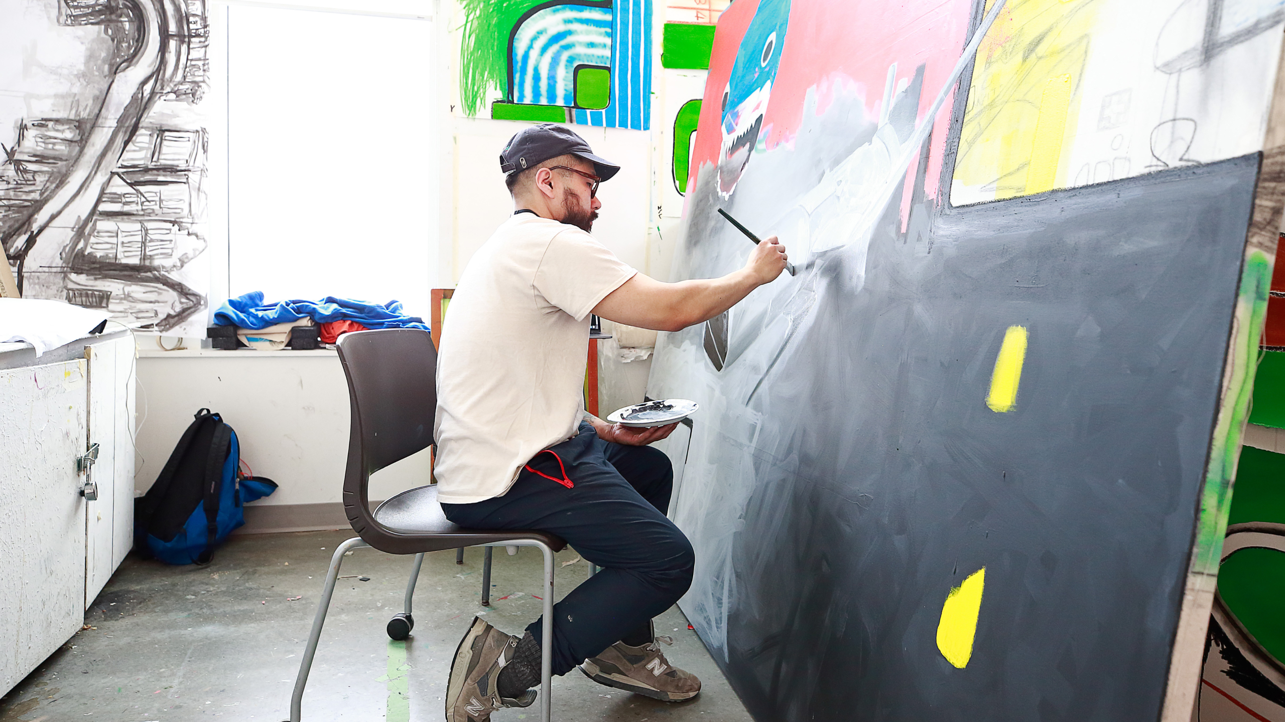 A student works on a large painting in an ECU painting studio.