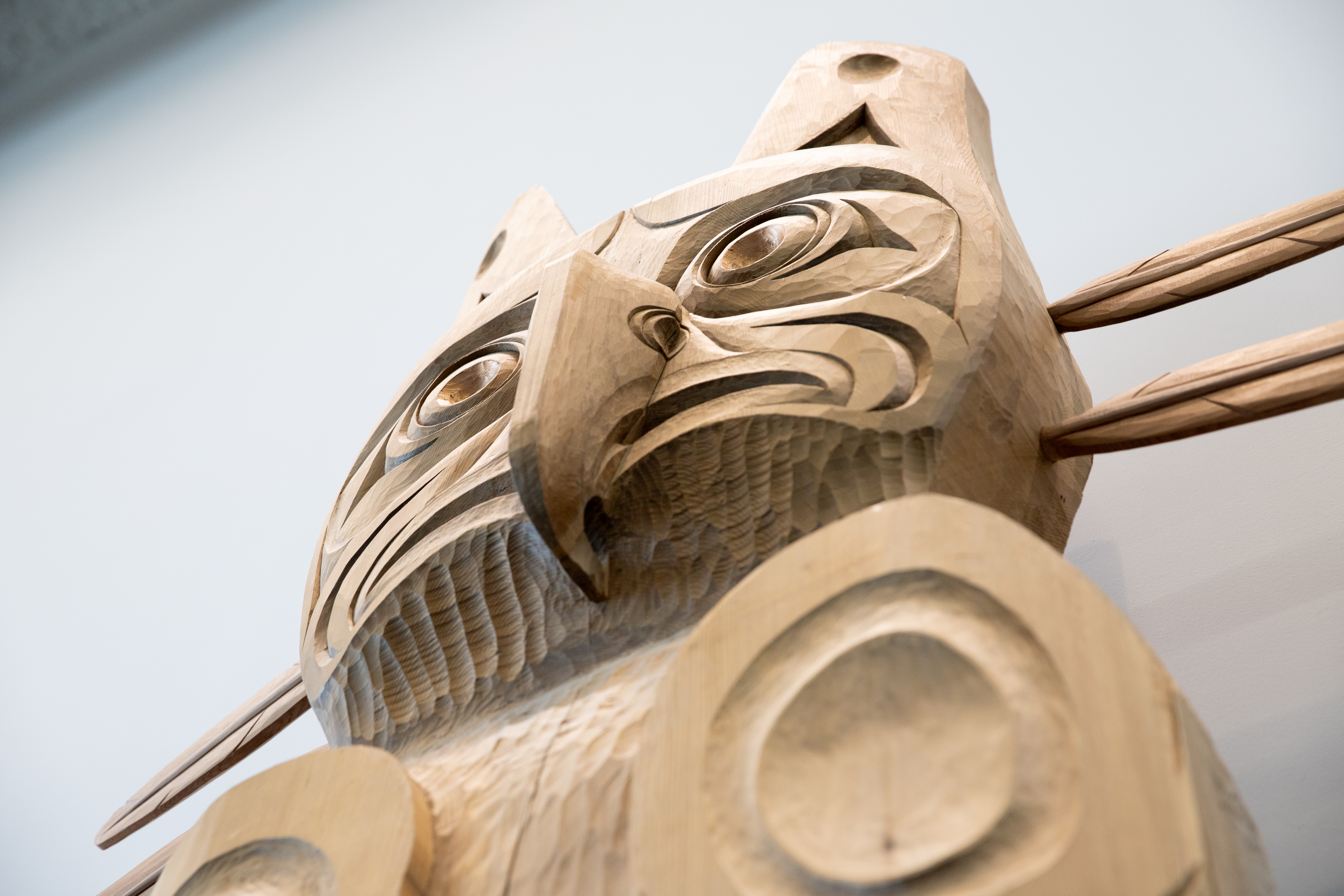 An upward shot of a wooden house post with a thunderbird