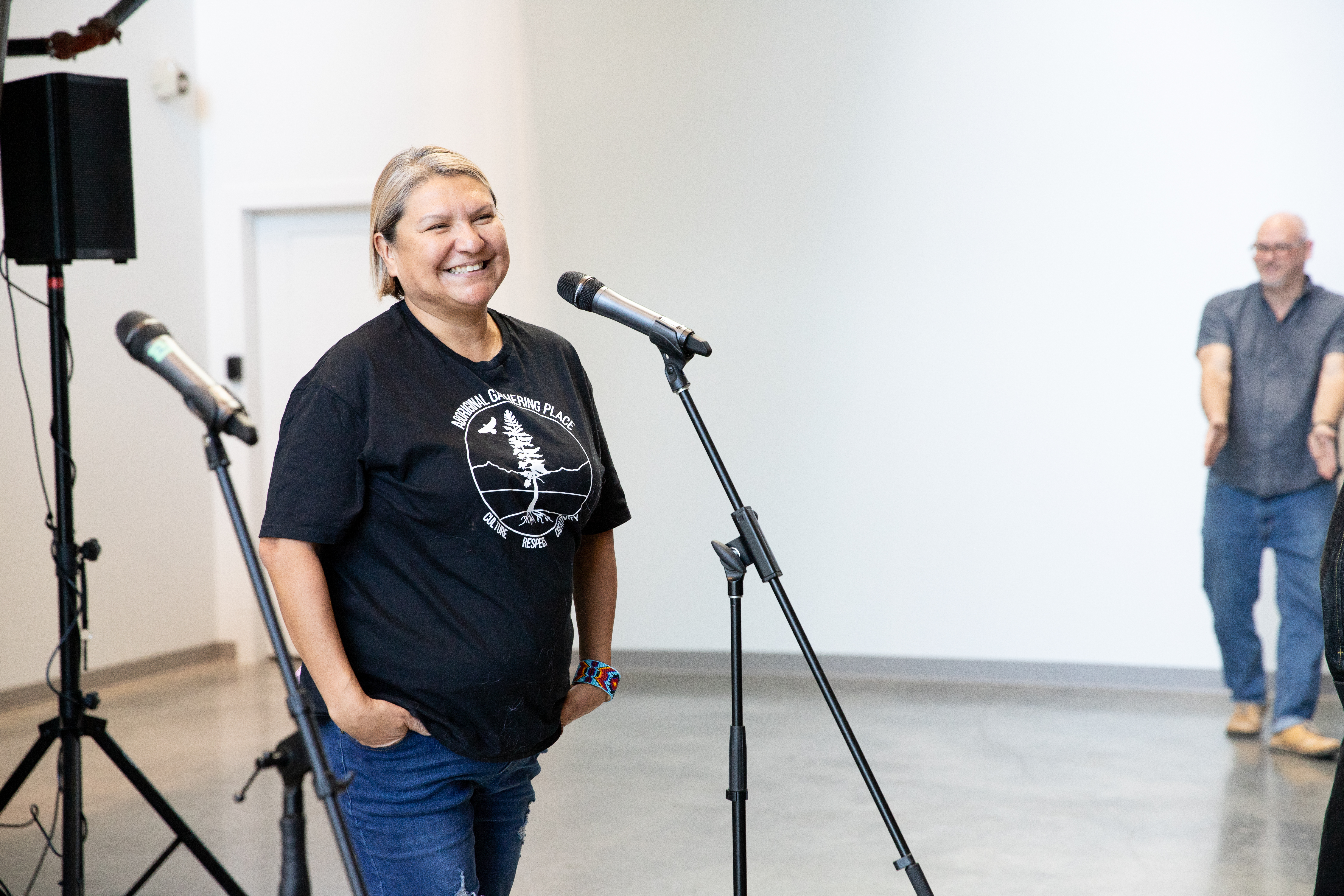 A woman stands in front of a microphone