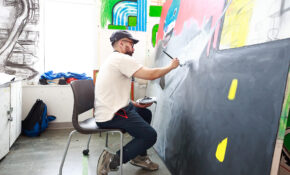A student works on a large painting in an ECU painting studio.
