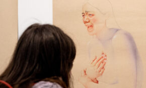 A person looks closely at an illustration of a crying woman.