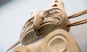 An upward shot of a wooden house post with a thunderbird