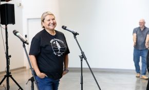 A woman stands in front of a microphone